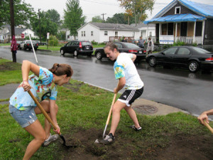 SyracuseCoE staff members Tara Nelson (left) and Suzy Englot -- members of "Team SyracuseCoE" -- dig out a flower bed on Ontario Street.