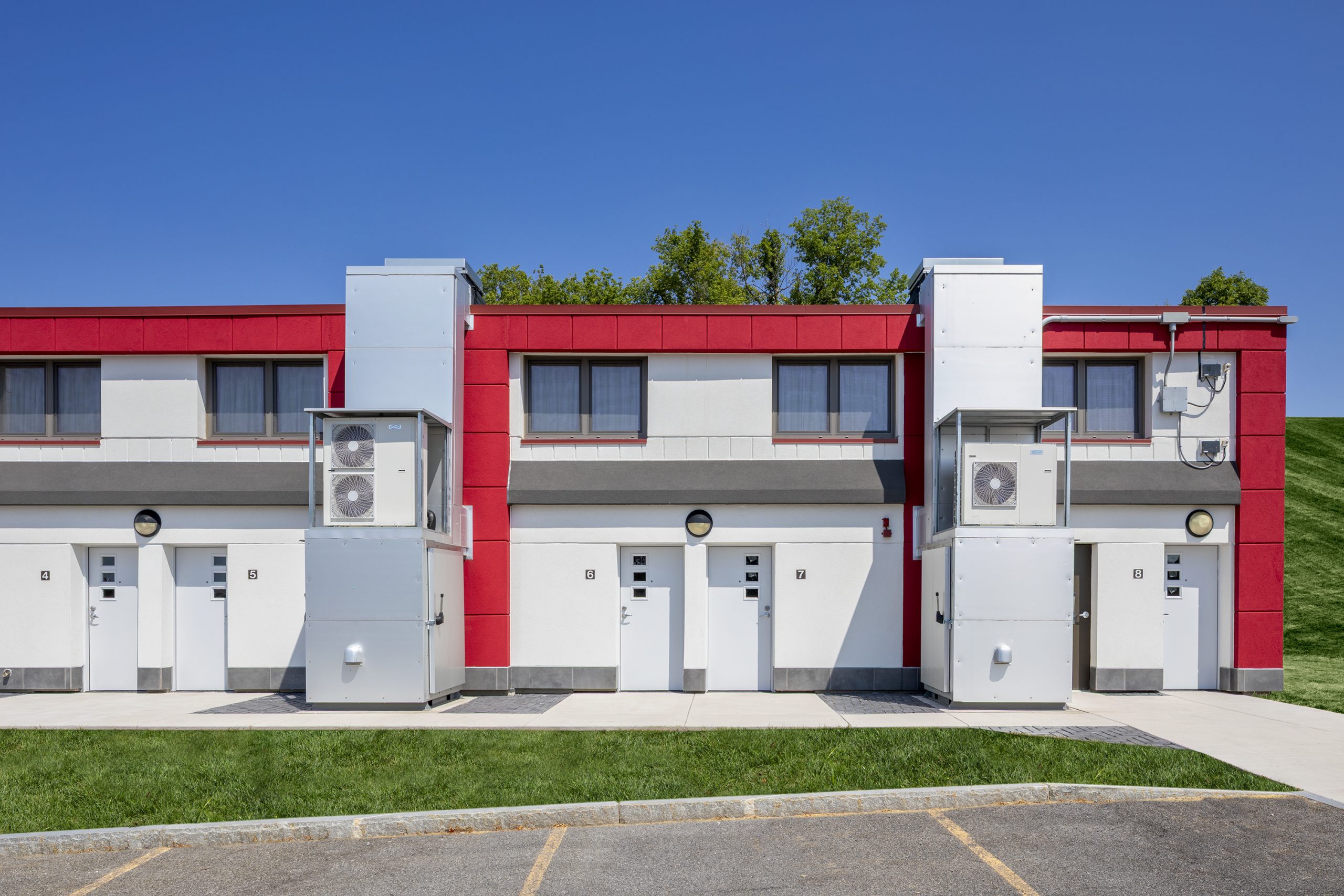 Exterior view of the retrofitted Lambreth Lane building with white doors and mechanical systems
