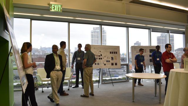 People looking at posters at CoE