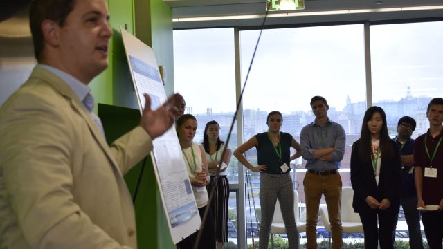 People listening to a talk at SyracuseCoE